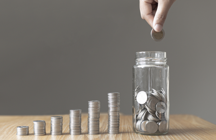 coins in rows with a jar full of coins