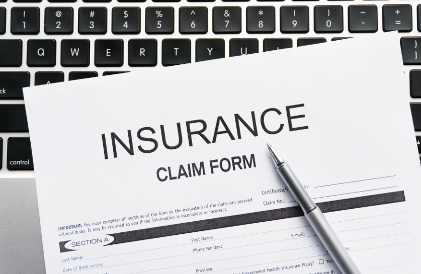 picture of an insurance claim form sitting on a computer keyboard