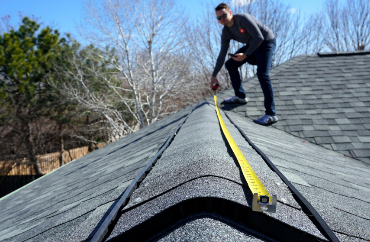 picture of a man on a roof taking measurements